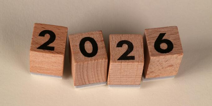 Vier Holzwürfel, jeweils eine 2, 0, 2 und 6. Sie bilden zusammen die Jahreszahl 2026
